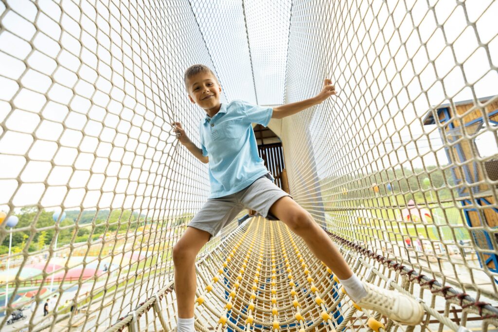 Boy climbs the nets at amusement park